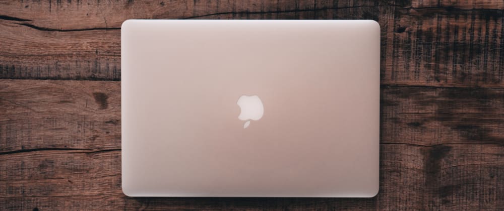 Top-down view of a closed silver macbook on a dark wood table